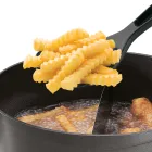 A close-up of the top of the DualDaddy electric deep fryer with French fries in the scoop.