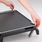 A close-up of the Tilt-n-Fold XL Electric Griddle's levers being flipped down.