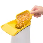 A close-up of the butter melter being used to pour popcorn kernels into the PopLite hot air popper.