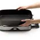 A close-up showing the skillet pan being detached from the base.