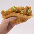 A waffle bowl being used to create a waffle taco.