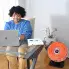 The HeatDish Plus Tilt parabolic electric heater and a woman working in an office.