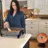 The HeatDish Plus Tilt parabolic electric heater and a woman working in the kitchen.