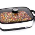 The Presto Precise 16-inch Tuxedo digital precision skillet multi-cooker with the cover on and a pizza cooking inside.