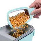 A close-up of the butter melter being used to pour popcorn kernels into the PopLite Plus hot air corn popper.