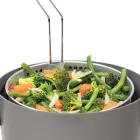 A close-up of the basket hooked to the rim of the multi-cooker. Steamed vegetables are in the basket.