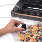 A close-up of the vacuum tube of the FreshDaddy Automatic Vacuum Sealer being used.
