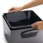 A close-up of hands removing the pot from the Dual Basket ProFry immersion element deep fryer's base.