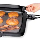 A close-up of the Cool-touch Electric Griddle/Warmer Plus with the tray being moved forward for steaming.