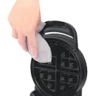 A close-up of the Flip Belgian Waffle Maker's cooking grid being cleaned.