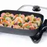 The 16-inch Electric Skillet with the cover off and shrimp cooking inside.