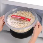 The Orville Redenbacher's PowerPop microwave multi-popper by Presto being removed from a microwave oven.
