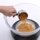 Popcorn kernels being poured into the Orville Redenbacher's PowerPop microwave multi-popper by Presto.