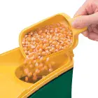 A close-up of the butter melter being used to pour popcorn kernels into the PopLite hot air popper.