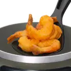 A close-up of the top of the FryDaddy electric deep fryer with deep fried shrimp in the scoop.