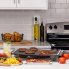 The Tilt-n-Fold XL Electric Griddle on a kitchen counter cooking breakfast sausage and bacon.