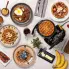 An overhead view of the FlipSide Belgian Waffle Maker with a baked waffle on the cooking grid and other baked waffles on plates around the waffle maker.