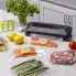 A kitchen counter with the FreshDaddy Automatic Vacuum Sealer and sealed bags of food.