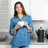 A woman enjoying a cup of coffee. The Cordless-serve 12-cup Stainless Steel Coffee Maker is on the kitchen counter.