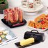 The PowerCrisp microwave bacon cooker on a kitchen counter with cooked bacon on the racks.