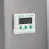 The Electronic Digital Timer with the magnet holding it to the side of a refrigerator.