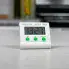 The Electronic Digital Timer on a countertop being held upright by the easel stand.