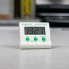 The Electronic Digital Timer on a countertop being held upright by the easel stand.