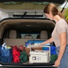 A woman placing the slow cooker in he back of an SUV.