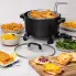 The Kitchen Kettle XL multi-cooker/steamer on a kitchen counter with fried fish in the basket. Several other foods are around the multi-cooker.