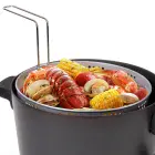 The Kitchen Kettle XL multi-cooker/steamer with the basket hooked to the rim. Steamed vegetables are in the basket.