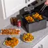 The Dual Basket ProFry immersion element deep fryer on a kitchen counter. Fried foods are in the baskets and in the foreground.