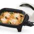 The 11-inch Electric Skillet with the cover off and food cooking in the pan.
