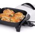 The 11-inch Electric Skillet with the cover off and chicken cooking in the pan.