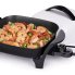 The 11-inch Electric Skillet with the cover off and shrimp cooking in the pan.