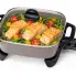 The 12-inch Electric Skillet with the cover on and salmon cooking in the pan.
