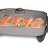 The 16-inch Electric Skillet with the cover on and salmon cooking in the pan.