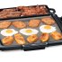 The Cool-touch Electric Griddle/Warmer Plus cooking hash browns, French toast, and fried eggs with bacon in the tray.