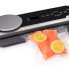 The FreshDaddy Vacuum Sealer with Digital Scale sealing a bag containing a salmon.