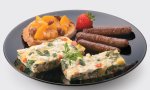 Summer vegetable frittata with peach chutney and breakfast sausage on a plate.