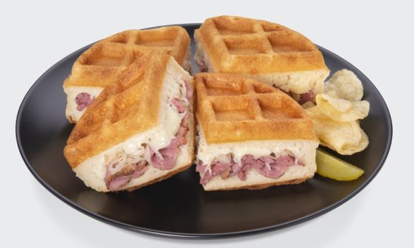 A Reuben stuffed waffle on a plate.