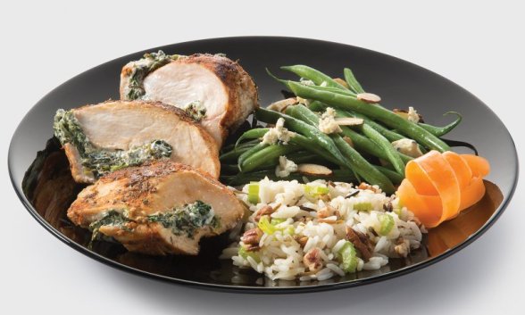 Spinach stuffed chicken, pecan rice, and green beans on a plate.