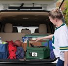 The Nomad Traveling Slow Cooker being placed in the back of a car.